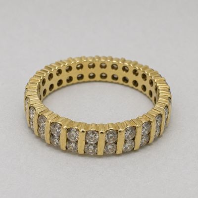 a close up of a gold and diamond ring on a white surface