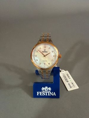 une photo d'une montre posée sur un présentoir, à laquelle est accrochée une étiquette
