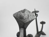 a black and white photo of a candle holder with two candles