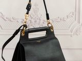 a black handbag with a gold handle on a wooden table