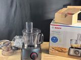 un mixeur posé sur une table à côté d'une boîte de provisions