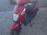 a red scooter parked on the side of the road