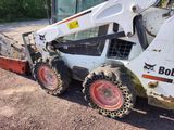 a picture of a bobcat skidder parked on the side of the road