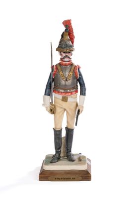 figurine of a soldier in uniform with a sword on a wooden base