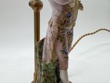 a figurine of a woman holding a bird on a table