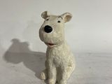 a small white dog figurine sitting on a white surface