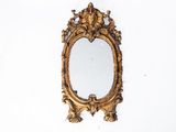 a gold mirror hanging on a wall next to a white wall
