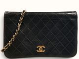 a black chanel purse with a gold chain hanging from it