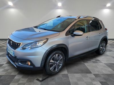 une voiture argentée est garée dans une pièce au sol en damier