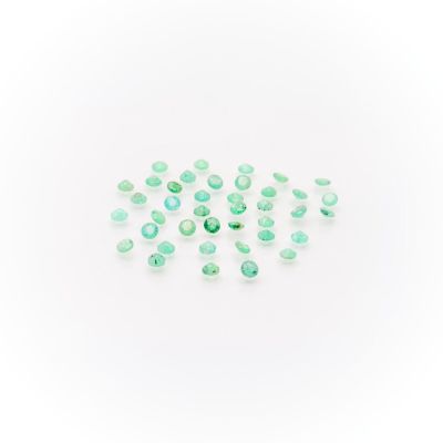 a pile of green glass beads on a white surface