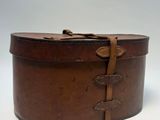une vieille boîte en cuir marron, entourée d'une lanière en cuir
