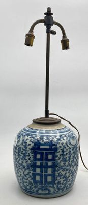 a blue and white vase with a light on it