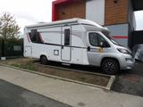 une photo d'un camping-car garé devant un immeuble