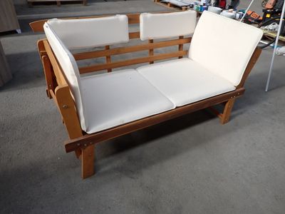 un canapé en bois avec des coussins blancs