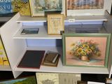 de nombreux tableaux sur les étagères de la pièce