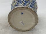 a blue and white vase sitting on a white surface