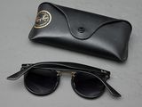 pair of black sunglasses and a black case on a gray surface