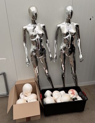 two mannequins that are standing next to a box of doughnuts