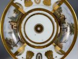 an image of a white and gold plate with a picture on it
