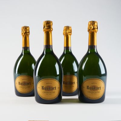 quatre bouteilles de champagne sont alignées sur une surface blanche