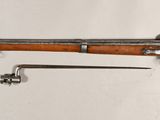 an old rifle is laying on a white surface next to a key