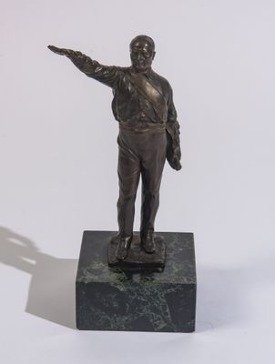 une statue en bronze représentant un homme tenant un pistolet