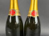 two bottles of champagne sitting next to each other on top of a table