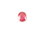 a close up of a red ruby stone on a white surface