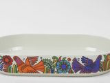 a white dish with colorful birds and flowers on it