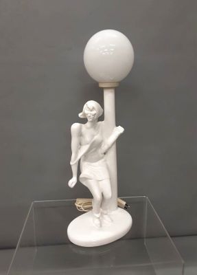 a white statue of a man holding a tennis racket