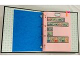 un classeur rose orné de timbres et doté d'une couverture bleue