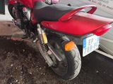 a red motorcycle parked in front of a white van