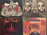 four cd ' s of various albums on a carpeted floor