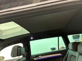 the interior of a car with the sunroof down and a laptop on the back seat