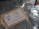 a glass vase with a tag on it sitting on a table