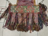 a small purse with fringes on a tile floor