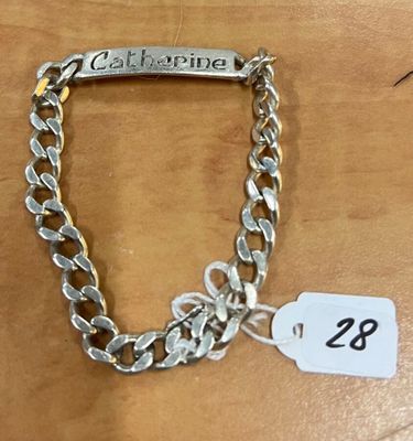 un bracelet en chaîne d'argent muni d'une plaque portant un prénom
