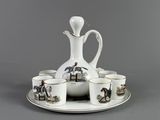 a white pitcher and six cups on a tray