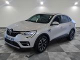a white car is parked on a checkered floor in a showroom