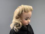 blond haired child with a black coat and a white shirt