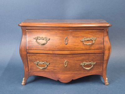 an old wooden chest of drawers with brass handles on a blue background