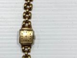 a close up of a bracelet with a gold clasp on a white background