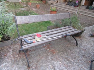 un banc en bois sur lequel est posé un chapeau, dans la cour