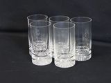 quatre verres transparents sont alignés sur une surface noire