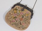 un petit sac à main orné de fleurs, suspendu à une chaîne