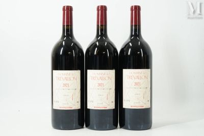 trois bouteilles de vin rouge sont alignées sur une surface blanche