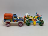 a toy truck and a toy motorcycle on a white surface