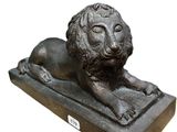 statue en bronze représentant un lion, posée sur un socle en pierre