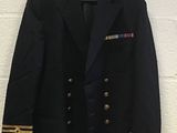 a black jacket with gold trims hanging on a white wall