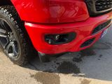 a red truck parked in a parking lot with snow on the ground